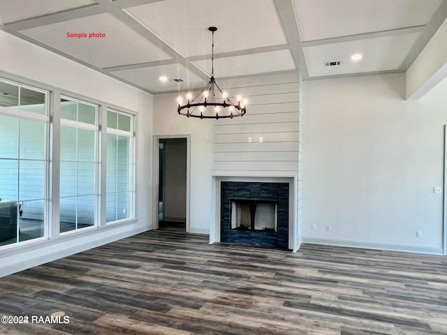 unfurnished living room with baseboards, visible vents, coffered ceiling, dark wood finished floors, and a notable chandelier