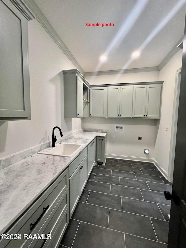laundry area with baseboards, cabinet space, a sink, washer hookup, and crown molding