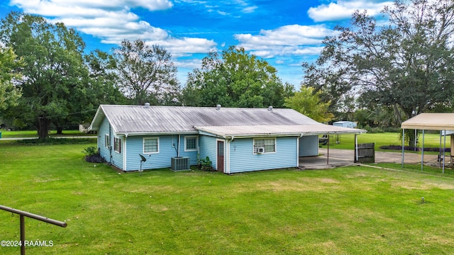 rear view of house with a lawn and a carport