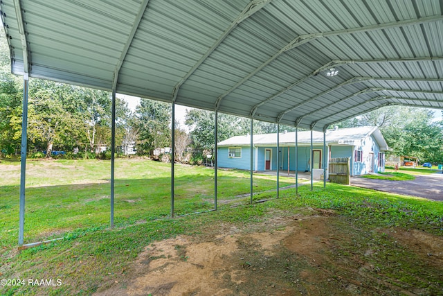 view of parking with a carport and a yard