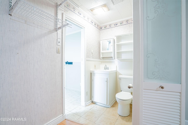 bathroom with tile patterned flooring, toilet, and crown molding