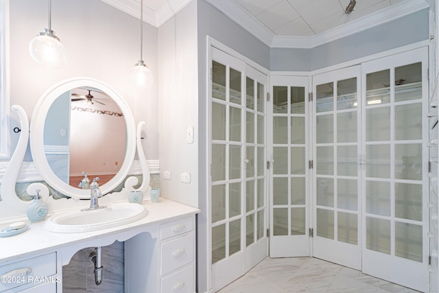 bathroom featuring ceiling fan, ornamental molding, and sink