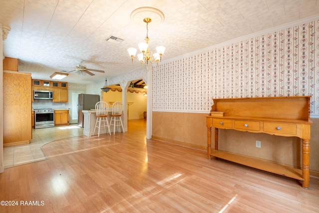 interior space featuring light hardwood / wood-style flooring, ceiling fan with notable chandelier, and ornamental molding