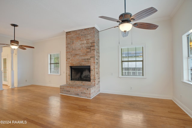 unfurnished living room featuring ornamental molding, ceiling fan, light hardwood / wood-style floors, and a fireplace