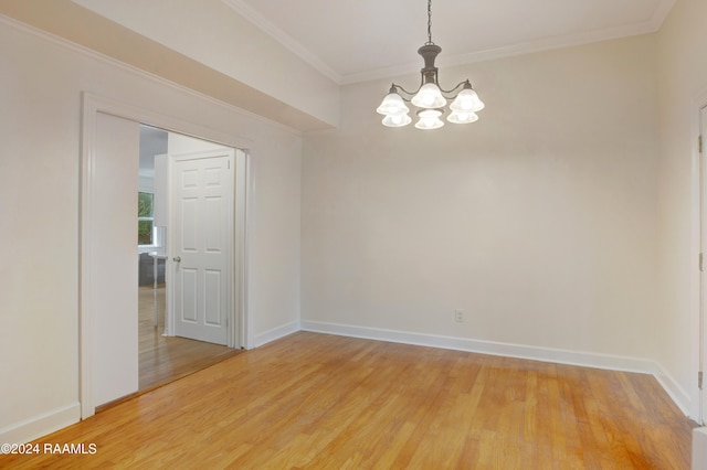 unfurnished room with hardwood / wood-style floors, crown molding, and a notable chandelier