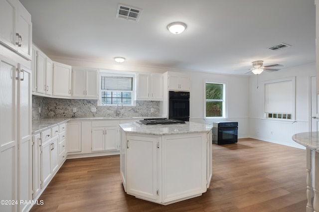 kitchen with white cabinetry, stainless steel gas cooktop, a wealth of natural light, and a kitchen island