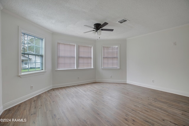 empty room featuring a textured ceiling, hardwood / wood-style flooring, crown molding, and ceiling fan