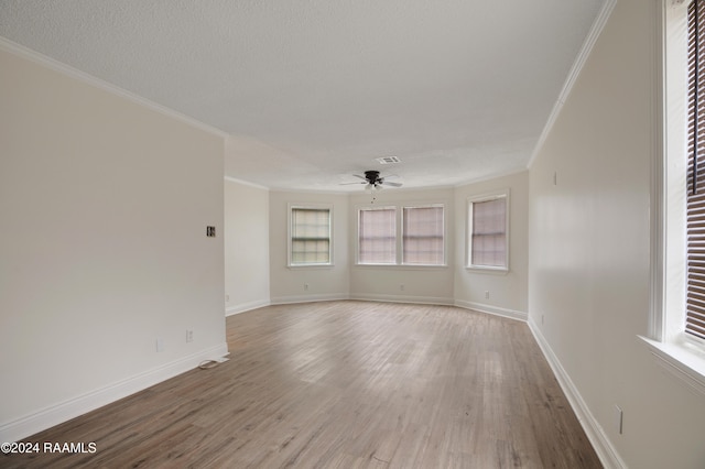 unfurnished room with hardwood / wood-style flooring, ceiling fan, a textured ceiling, and crown molding