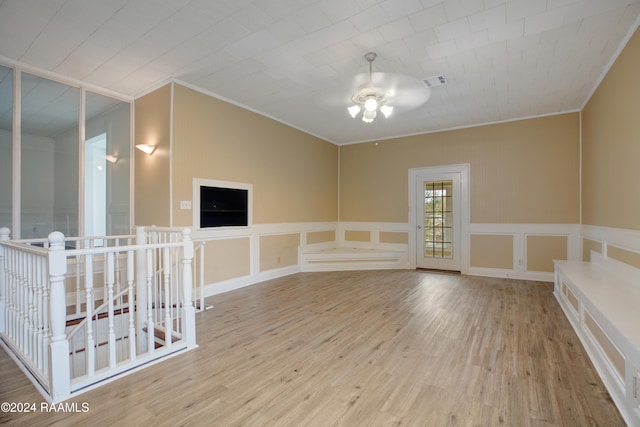 spare room with light hardwood / wood-style floors and crown molding