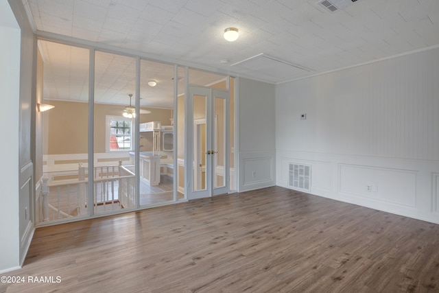 spare room with wood-type flooring, ceiling fan, and crown molding