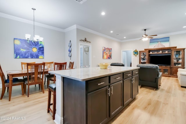 kitchen featuring a center island, light hardwood / wood-style floors, hanging light fixtures, and ornamental molding