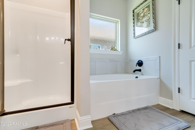 bathroom with a tub to relax in and hardwood / wood-style floors