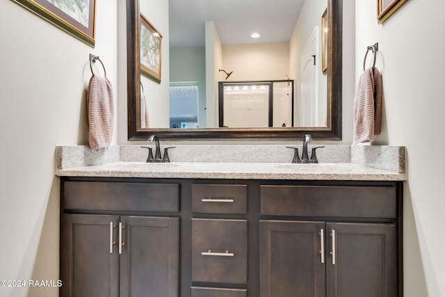 bathroom with a shower with door and vanity