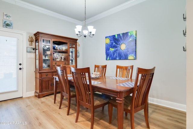 dining area with a notable chandelier, light hardwood / wood-style floors, and crown molding