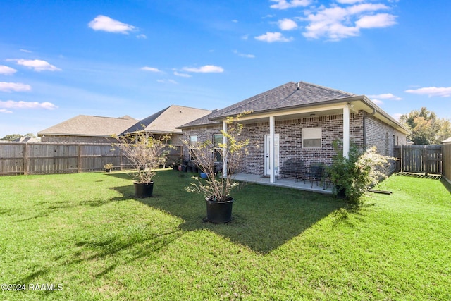 back of house featuring a patio area and a yard