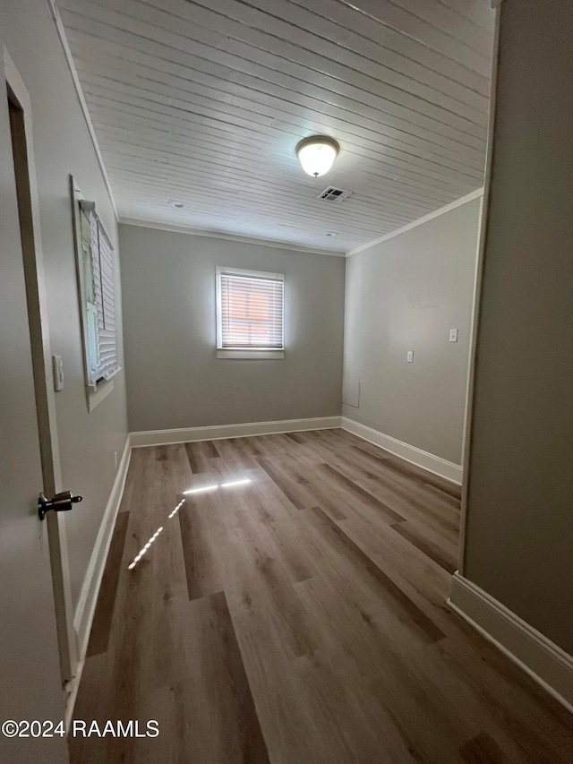 unfurnished room with hardwood / wood-style flooring, crown molding, and wood ceiling