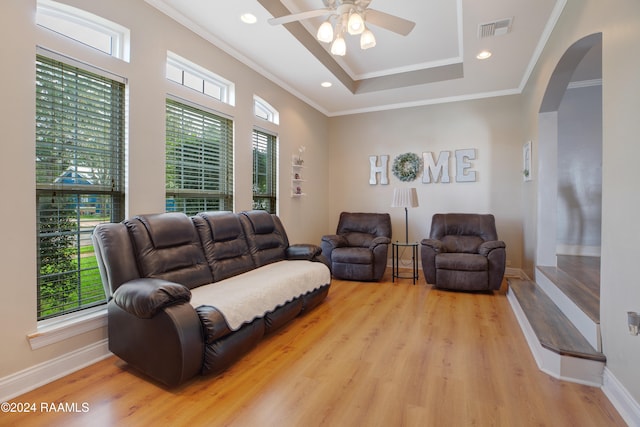 living room with plenty of natural light, light hardwood / wood-style flooring, and ornamental molding