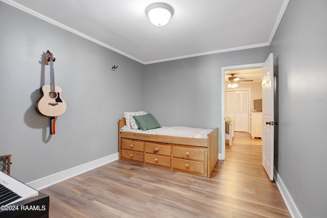 bedroom with light hardwood / wood-style floors and crown molding