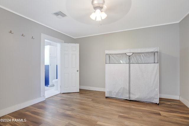 unfurnished bedroom with ornamental molding, hardwood / wood-style flooring, ceiling fan, and ensuite bathroom