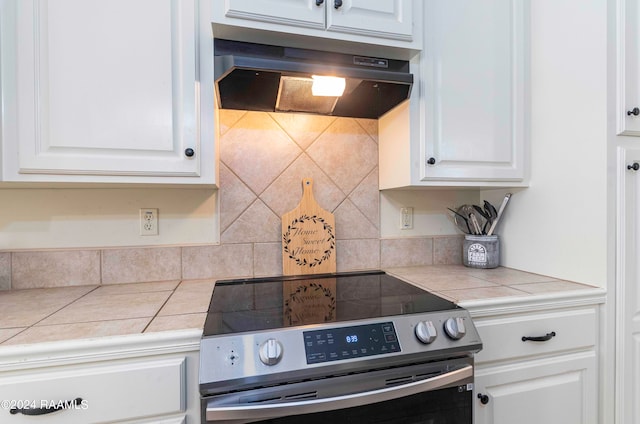 kitchen with tile counters, white cabinetry, stainless steel range with electric cooktop, and decorative backsplash