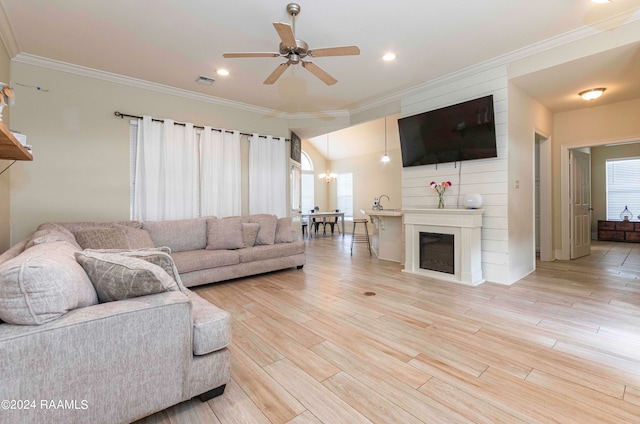 living room with ceiling fan, plenty of natural light, and light hardwood / wood-style flooring