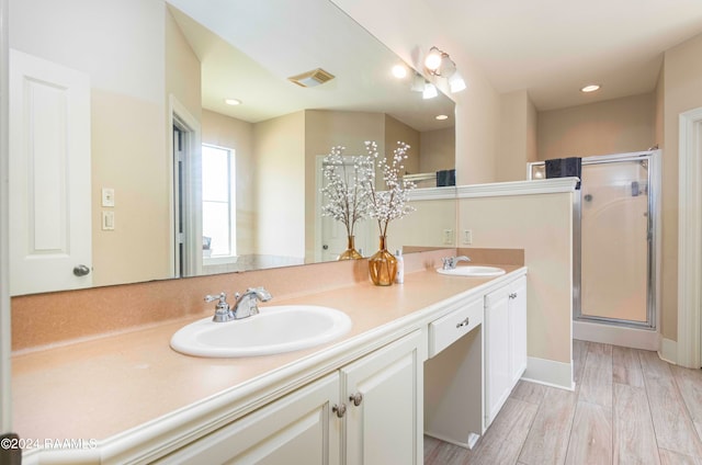 bathroom with walk in shower, vanity, and wood-type flooring