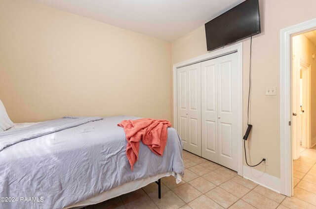 bedroom featuring light tile patterned flooring and a closet