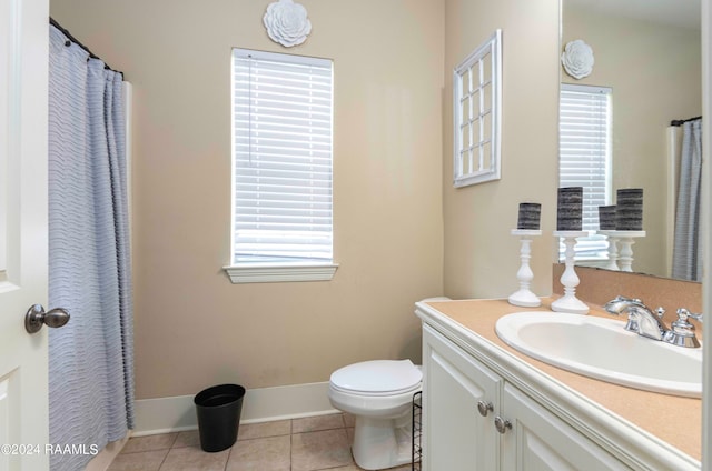 bathroom featuring toilet, vanity, tile patterned flooring, and plenty of natural light