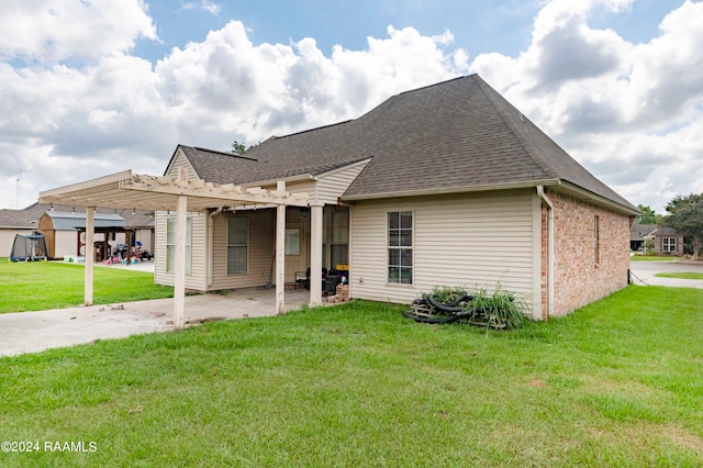 back of property with a pergola, a lawn, and a patio