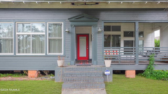 view of exterior entry featuring a yard