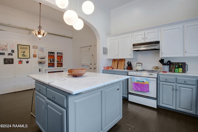 kitchen featuring a kitchen island, dark hardwood / wood-style floors, pendant lighting, white cabinetry, and gas range gas stove