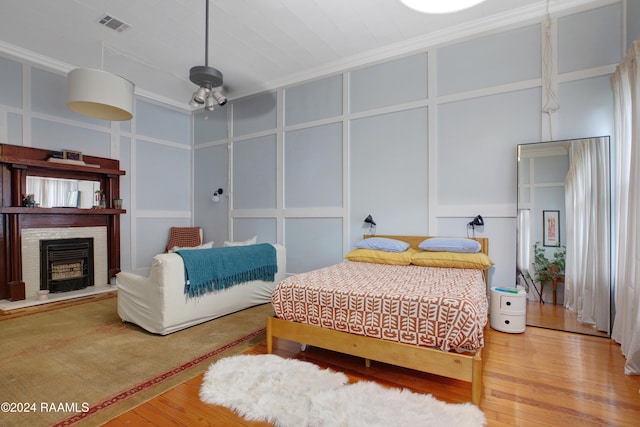 228 Cherry St, Lafayette, LA 70506 - bedroom featuring a decorative wall, wood finished floors, a fireplace, and crown molding