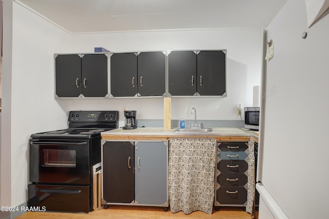 228 Cherry St, Lafayette, LA 70506 - kitchen with a sink, black / electric stove, light countertops, light wood-type flooring, and freestanding refrigerator