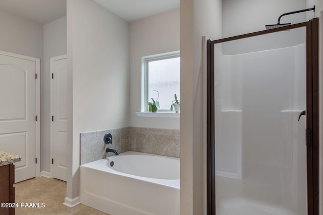 bathroom with independent shower and bath, vanity, and tile patterned floors