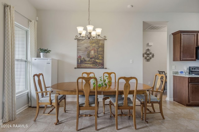 dining area featuring an inviting chandelier, light tile patterned flooring, and plenty of natural light