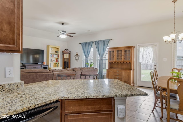 kitchen featuring light stone countertops, ceiling fan with notable chandelier, light tile patterned floors, hanging light fixtures, and dishwasher