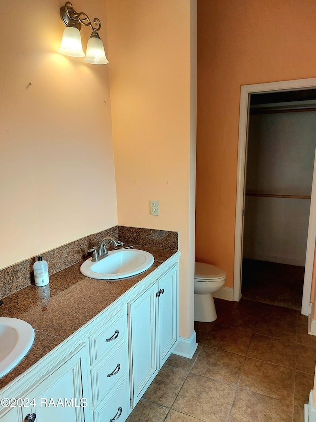 bathroom featuring tile patterned flooring, vanity, and toilet