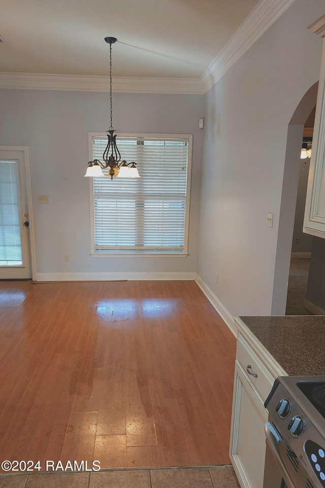 unfurnished dining area with light hardwood / wood-style flooring and crown molding