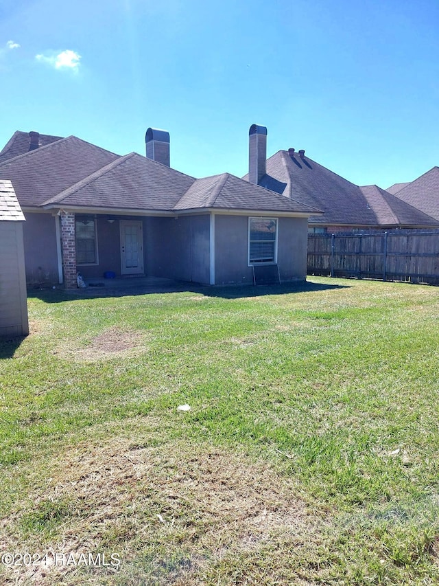 rear view of house featuring a lawn