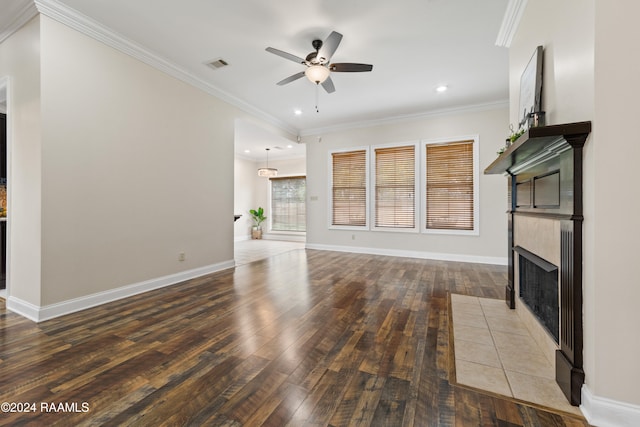 unfurnished living room with hardwood / wood-style floors, ceiling fan, ornamental molding, and a tiled fireplace