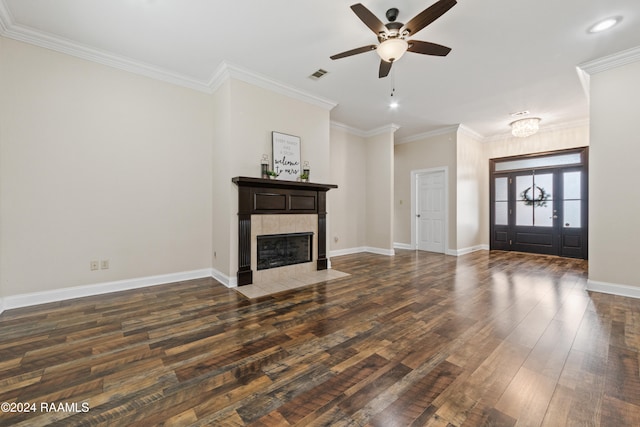 unfurnished living room with dark hardwood / wood-style floors, ceiling fan, crown molding, and a tile fireplace