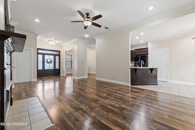 unfurnished living room featuring french doors, dark hardwood / wood-style flooring, ceiling fan, and ornamental molding