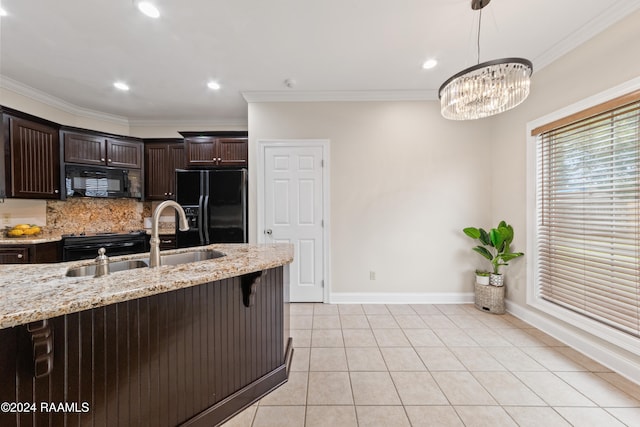 kitchen featuring light stone counters, dark brown cabinetry, crown molding, sink, and black appliances