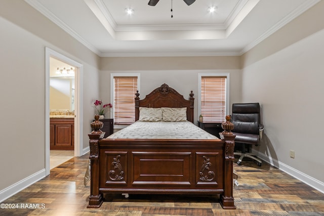 bedroom with a raised ceiling, ensuite bath, dark hardwood / wood-style floors, ceiling fan, and ornamental molding