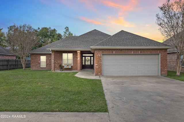 view of front of house featuring a garage and a lawn