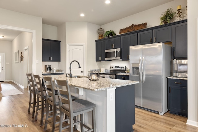 122 Cainwood Ct, Carencro, LA 70520 - kitchen featuring appliances with stainless steel finishes, a sink, light wood finished floors, light stone countertops, and recessed lighting