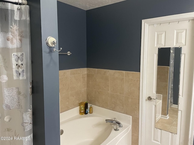 bathroom featuring a textured ceiling, tile patterned flooring, and a bathing tub