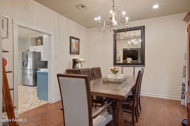 dining space featuring a chandelier, light wood-type flooring, and crown molding