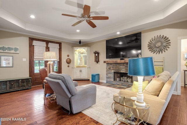 living room featuring hardwood / wood-style floors, a fireplace, and a tray ceiling