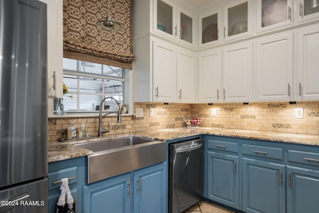 kitchen with blue cabinets, white cabinets, sink, backsplash, and appliances with stainless steel finishes